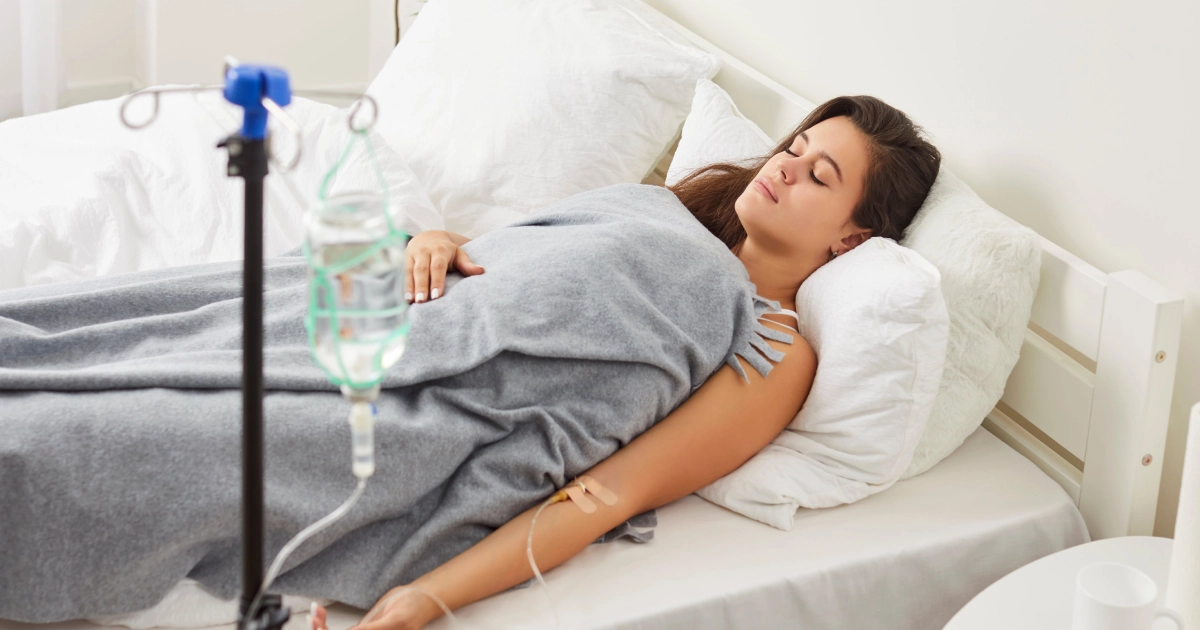 Woman resting in bed with IV drips treatment at Miramar Beach, FL